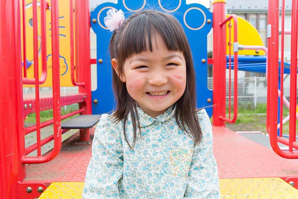 Smiling little girl in playground without background bokeh
