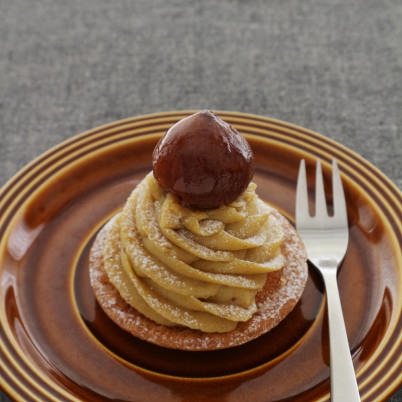 Caramel tart on brown plate and dark grey background
