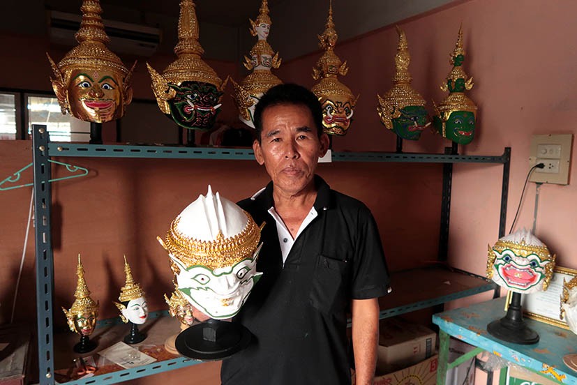 Prateep Rodpai poses with one of the many masks in his studio.