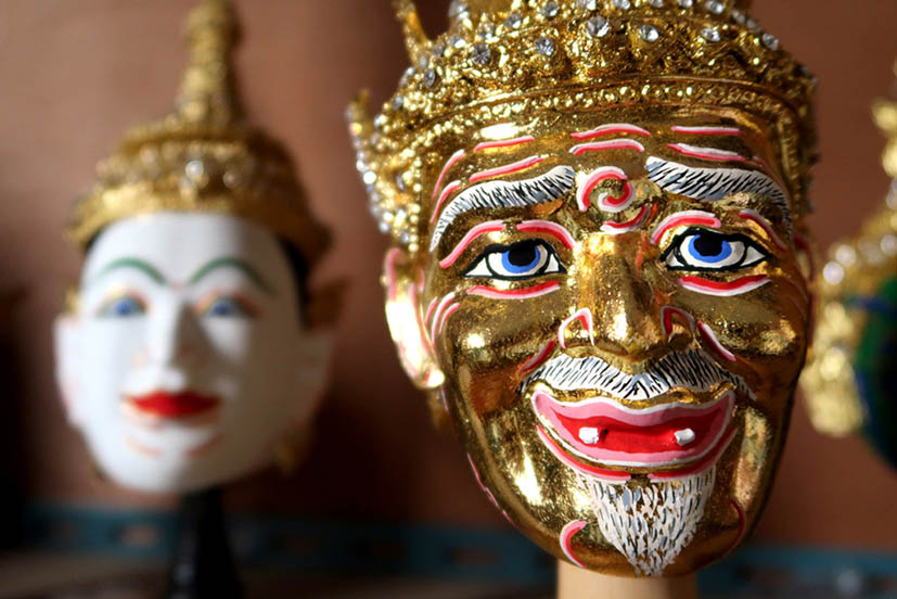 A golden Thai Khon mask showing a hermit character.