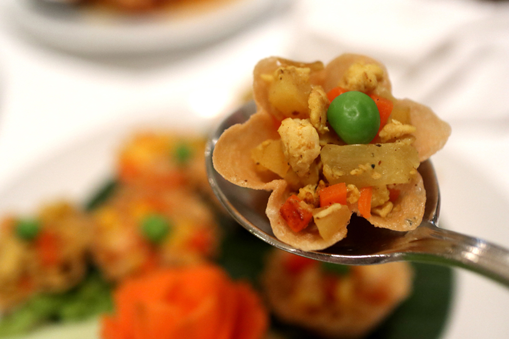 An appetiser of minced shrimp with green peas and sweet corn in a crispy pastry shell.