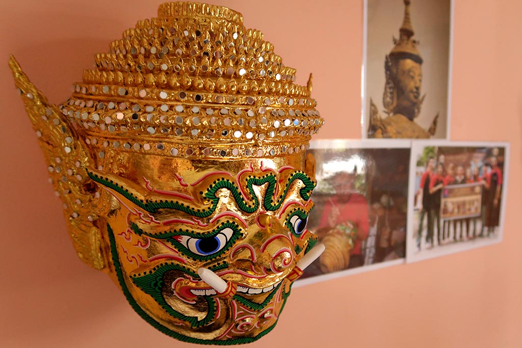 A golden mask of a giant character, characterised by its large fangs.