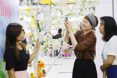 Ms. Yajima shows a participant how to take a photo at Canon photobooth in Dagon Centre