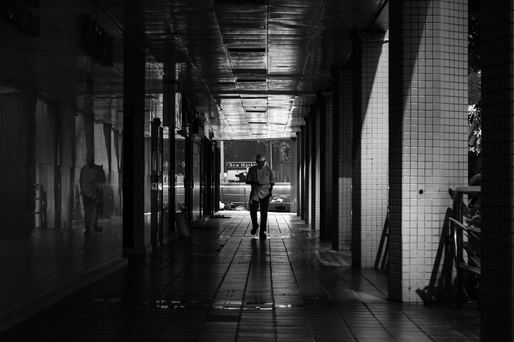 man along a walkway, black and white