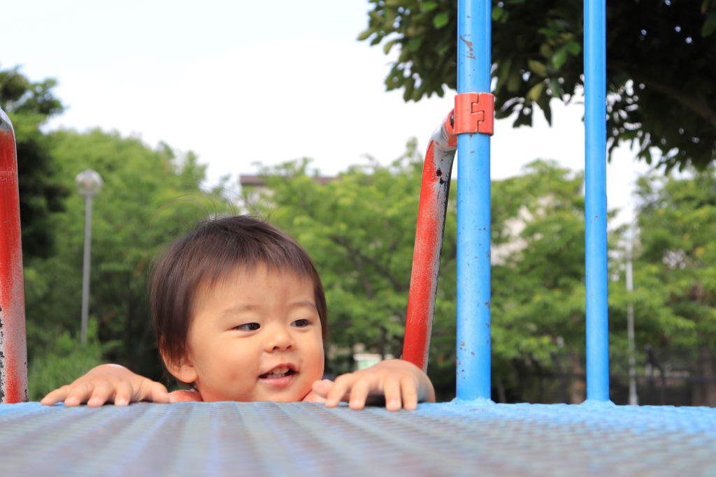 Low angle shot of child climbing up slide