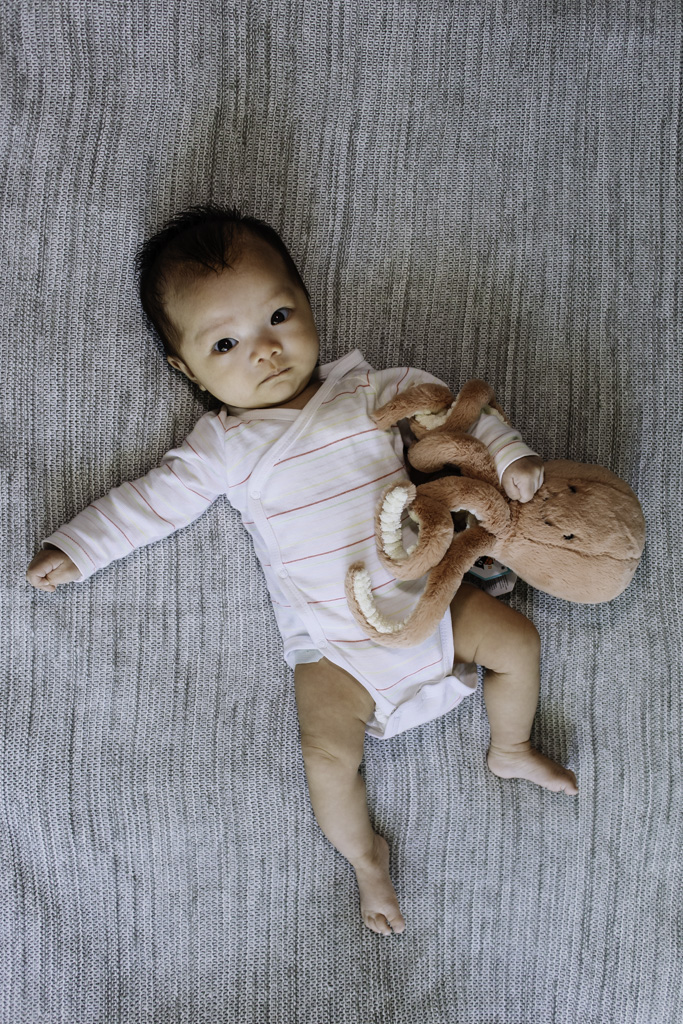 baby with plushie lying down