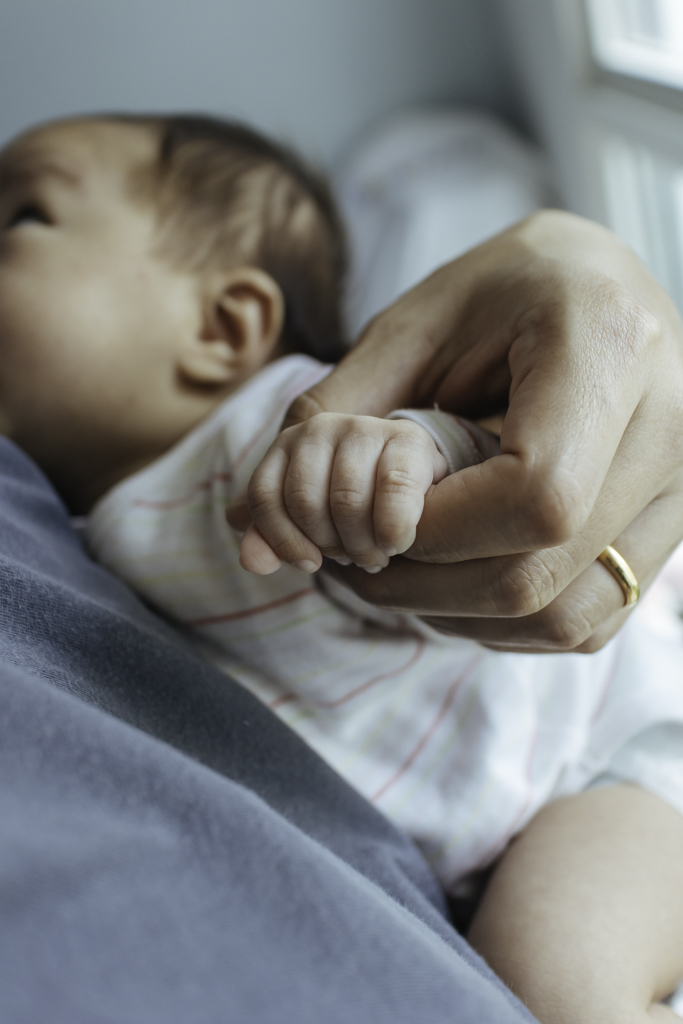 father holding baby's hand
