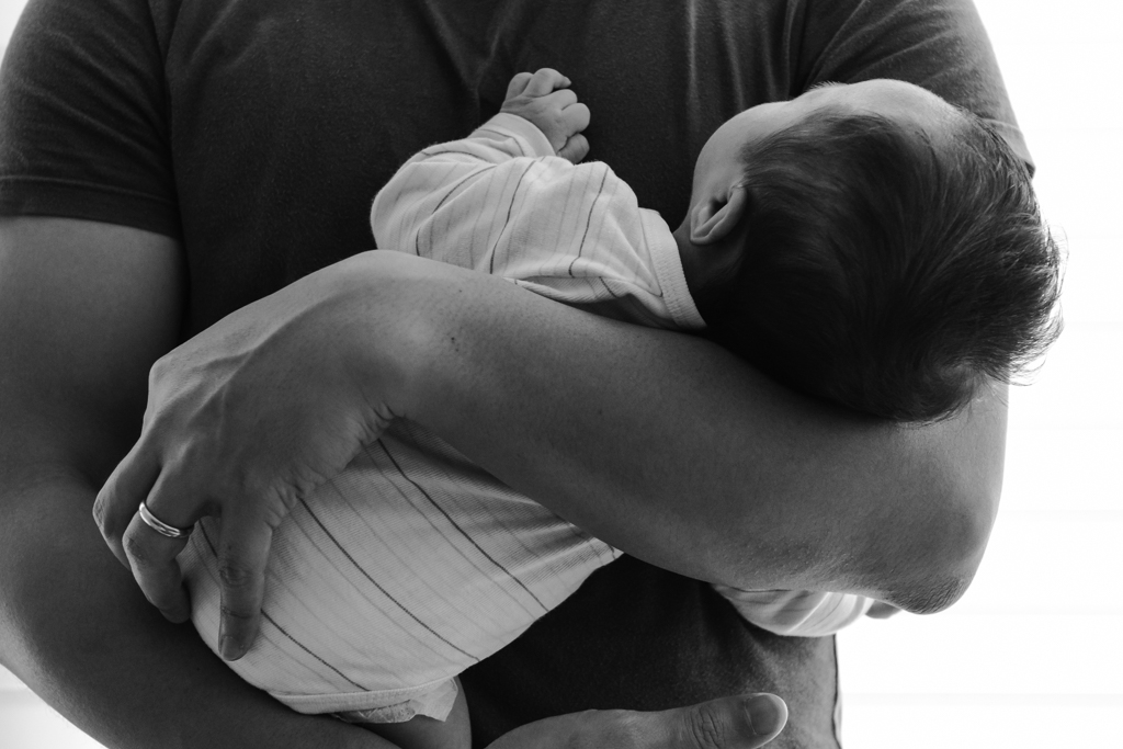 black and white father craddling baby