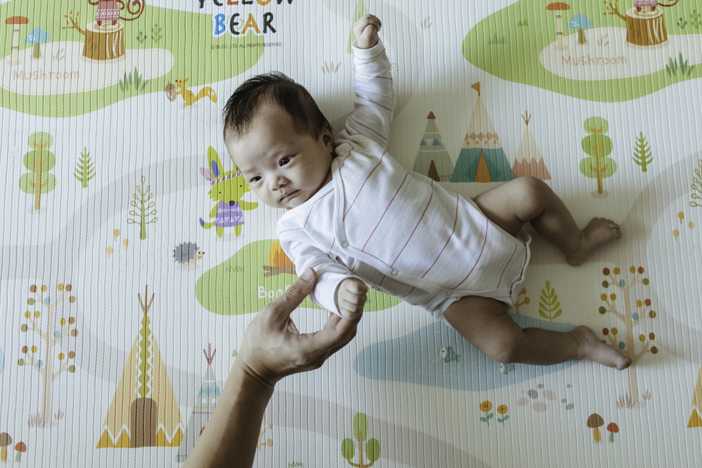 baby lying on playmat