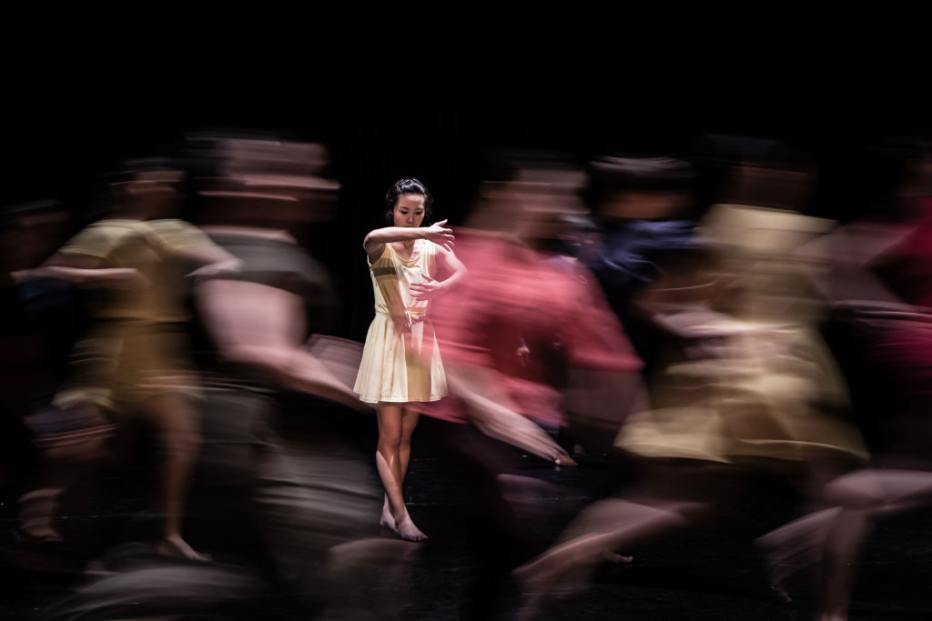 Colourful slow shutter shot of dancers moving around stage