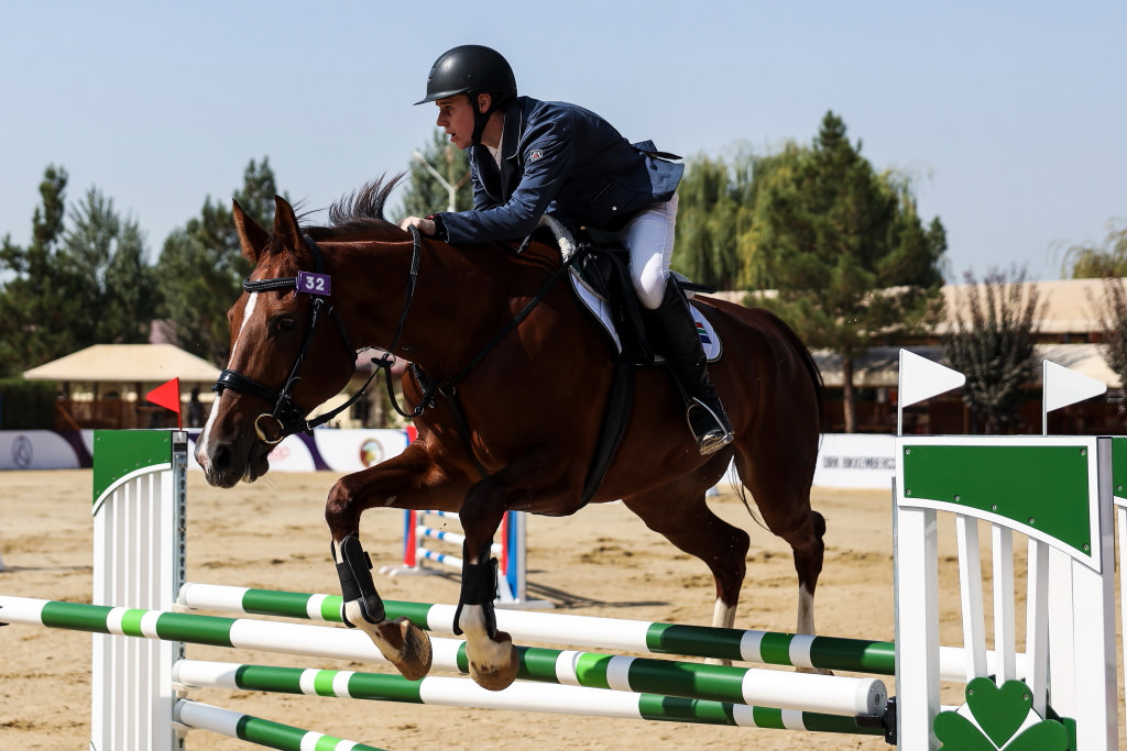 Horse and rider jumping over fence