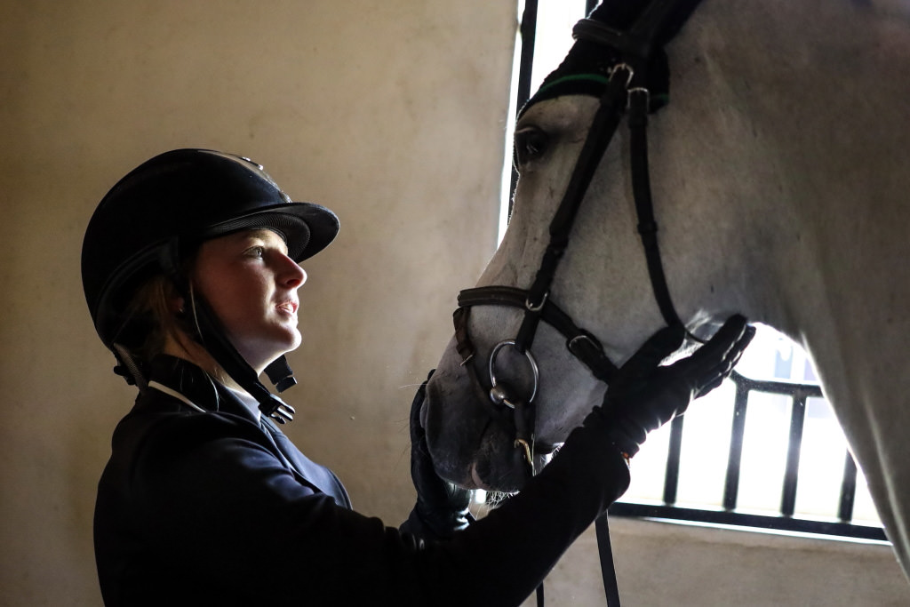 Horse and rider in dark stable