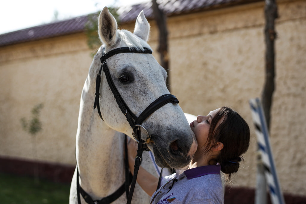 Rider bonding with horse outdoors in daylight