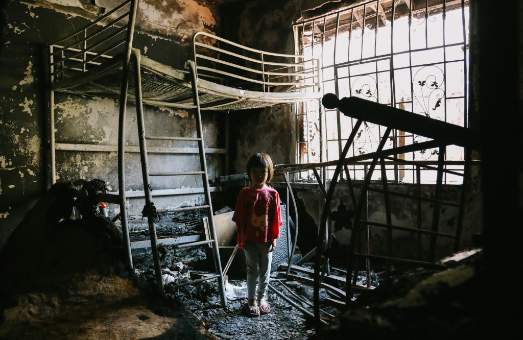 Little girl in burnt room after fire at orphanage