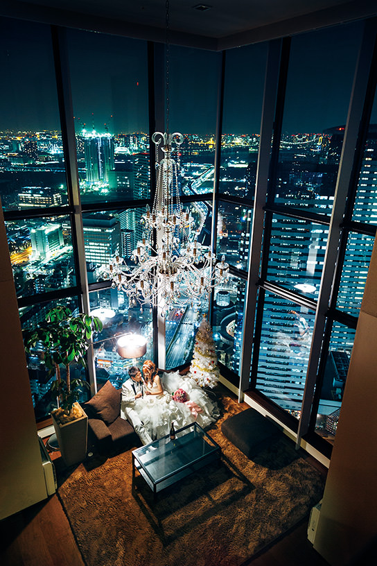 Bride and groom seated in room with night scene background