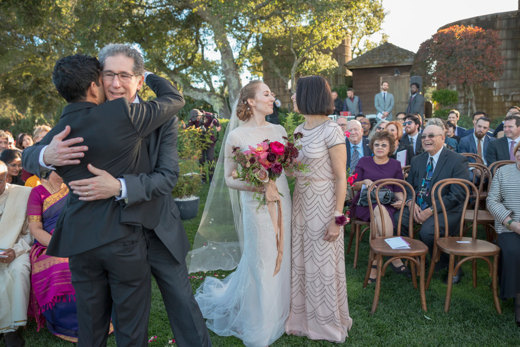 Bridegroom and father of bride hugging