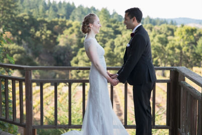 Bride and groom hold hands and gaze at each other