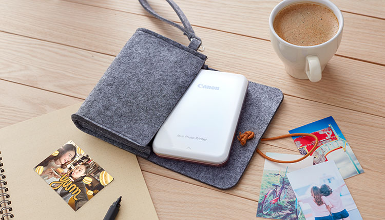 Canon Mini Photo Printer on the table with photo printouts