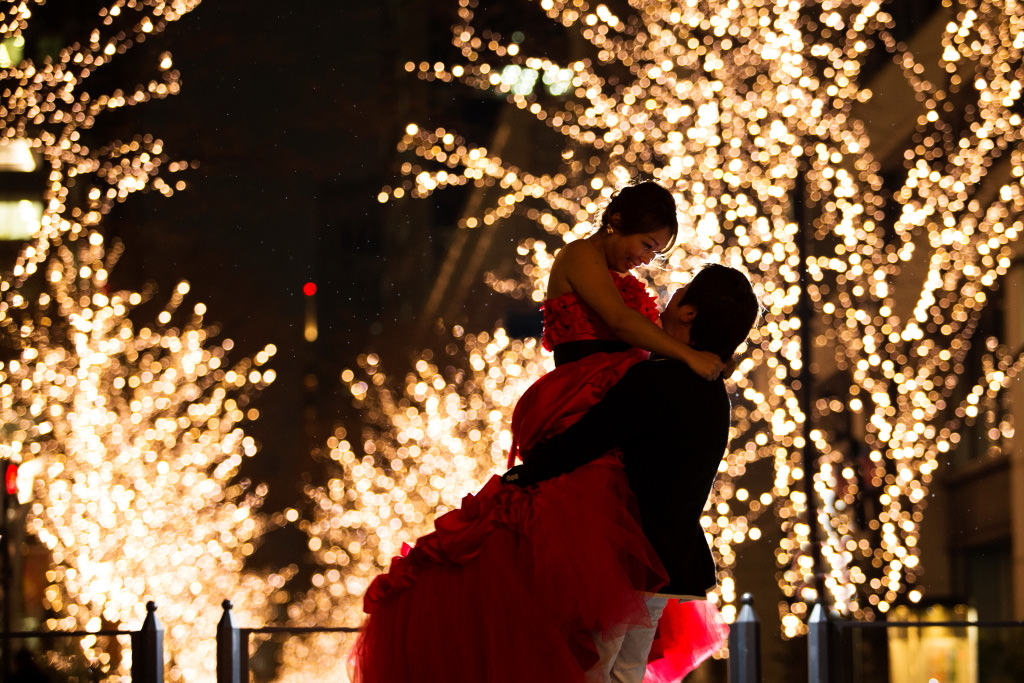 Groom carries bride among sea of lights