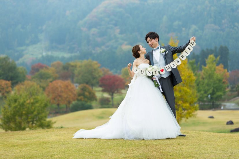 Couple in front of mountains with “Just Married” sign