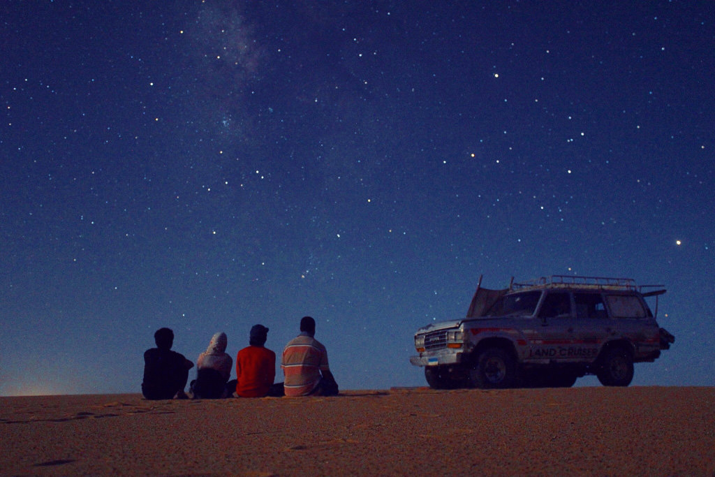 Heavily edited shot of people viewing the night sky