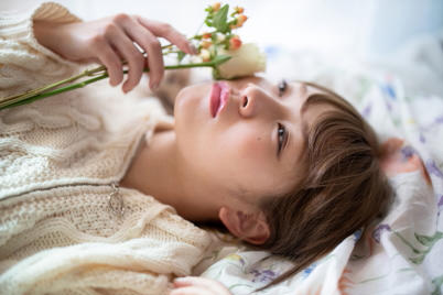 Girl lying down, flower out of focus