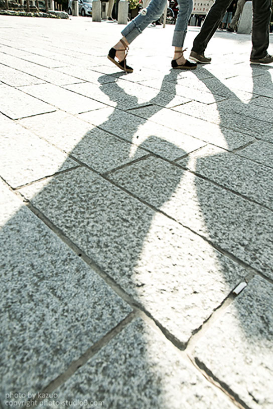 Shadows of passers-by on the street.
