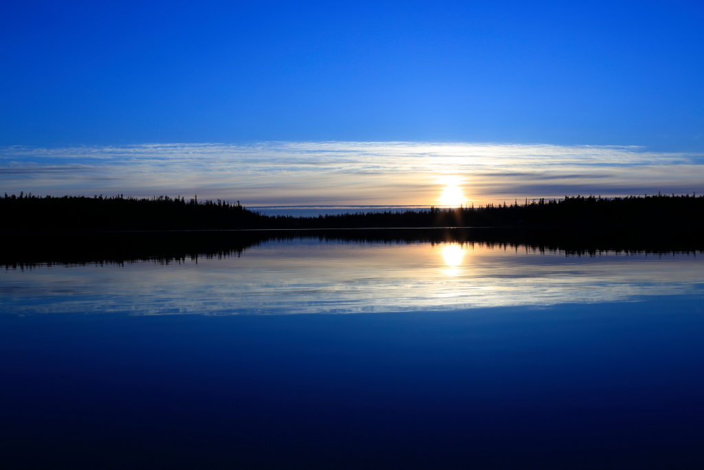 Tranquil lake with trees and clouds
