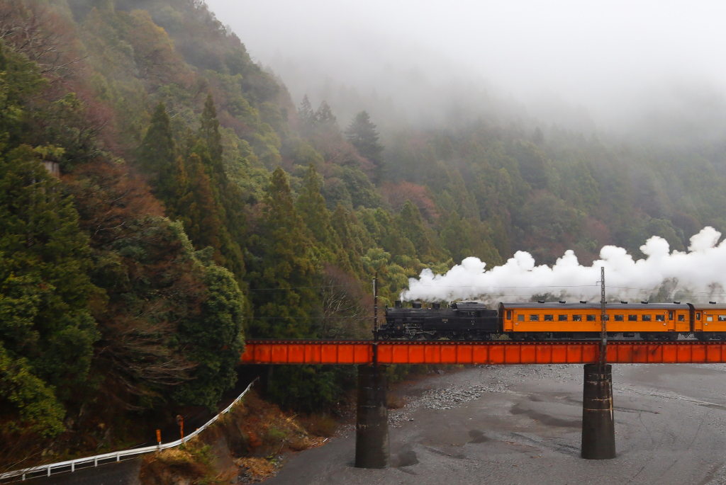 Steam train on bridge over river