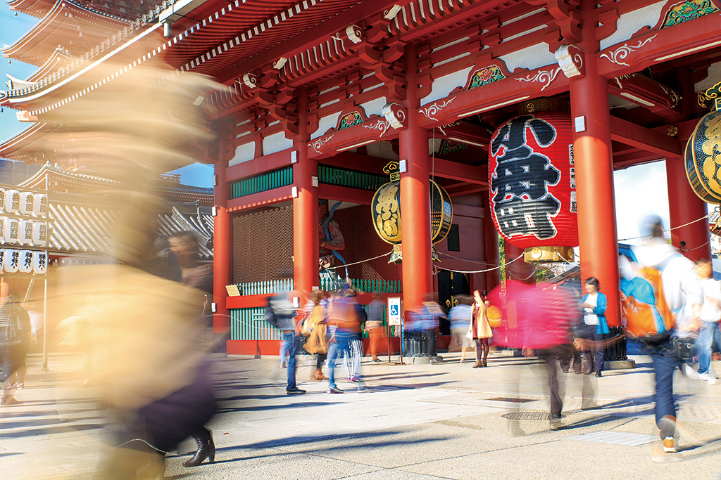 Passers-by with motion blur in front of temple