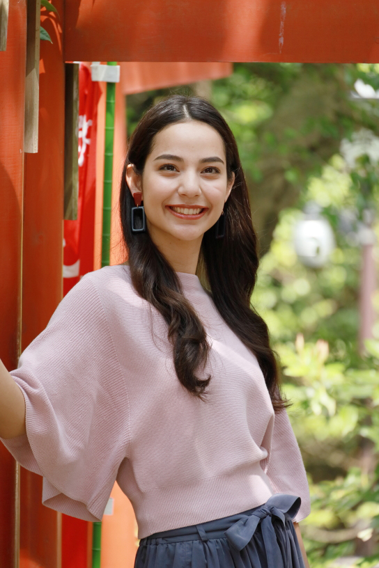 Vertical portrait of girl in front of torii