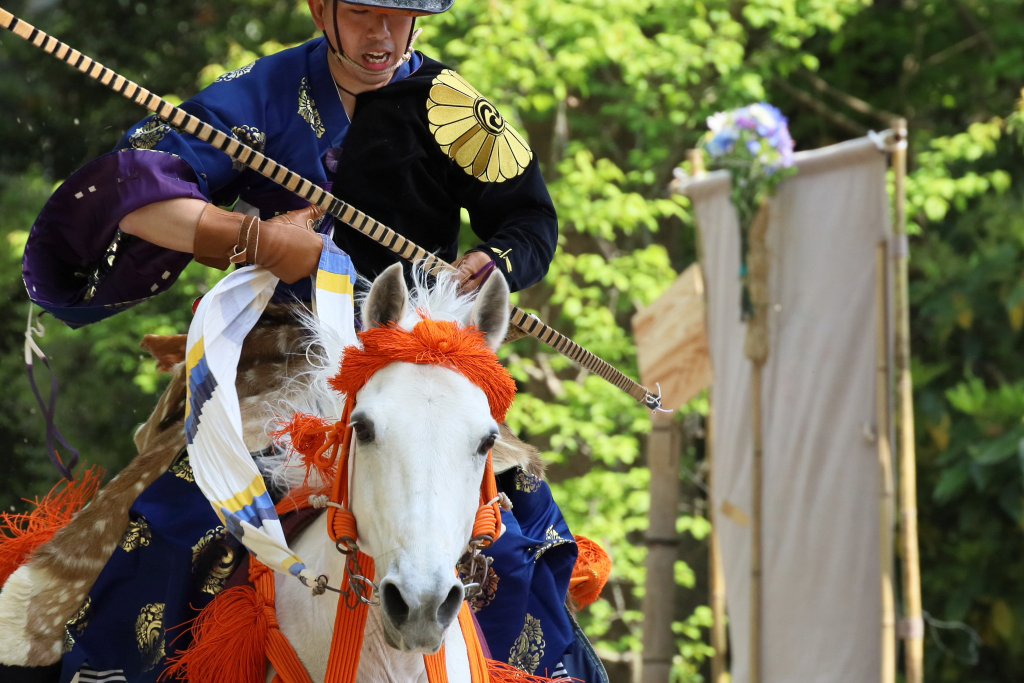Action portrait of man on horse in Japanese traditional costume