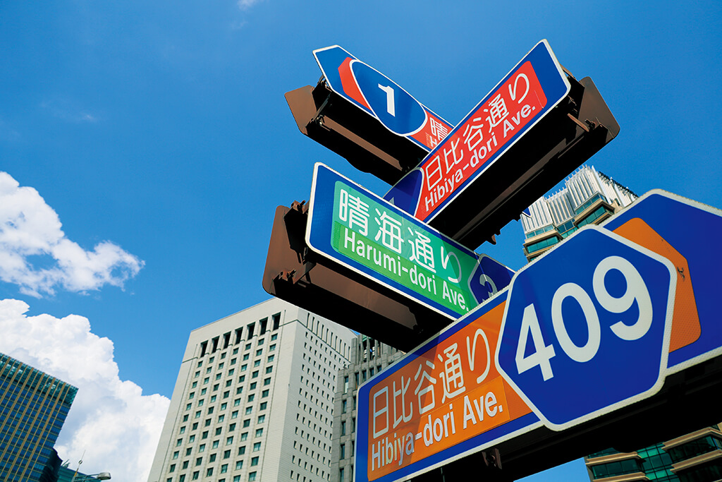 Close-up of street signs against the sky