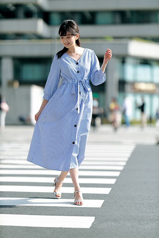 Model posing on road in front of buildings