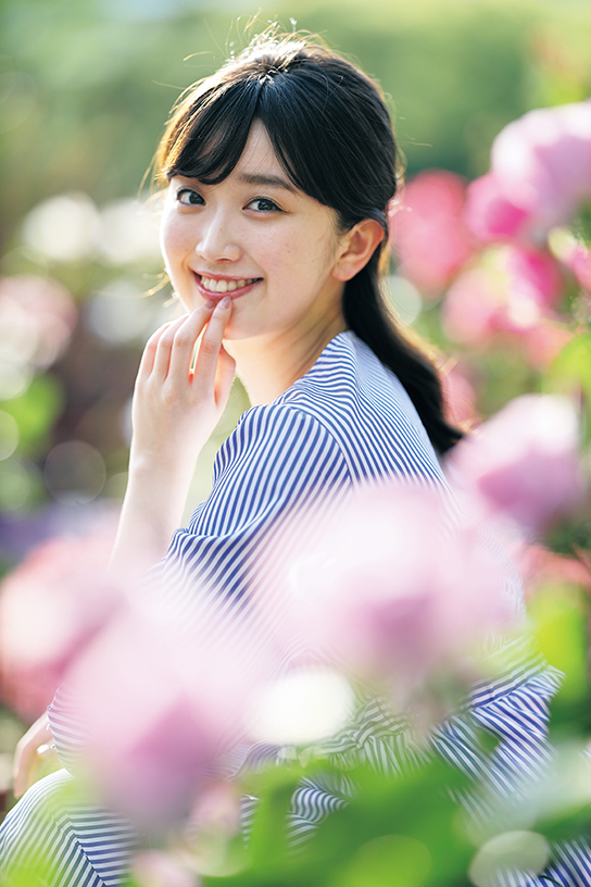 Model seated with foreground and background bokeh flowers