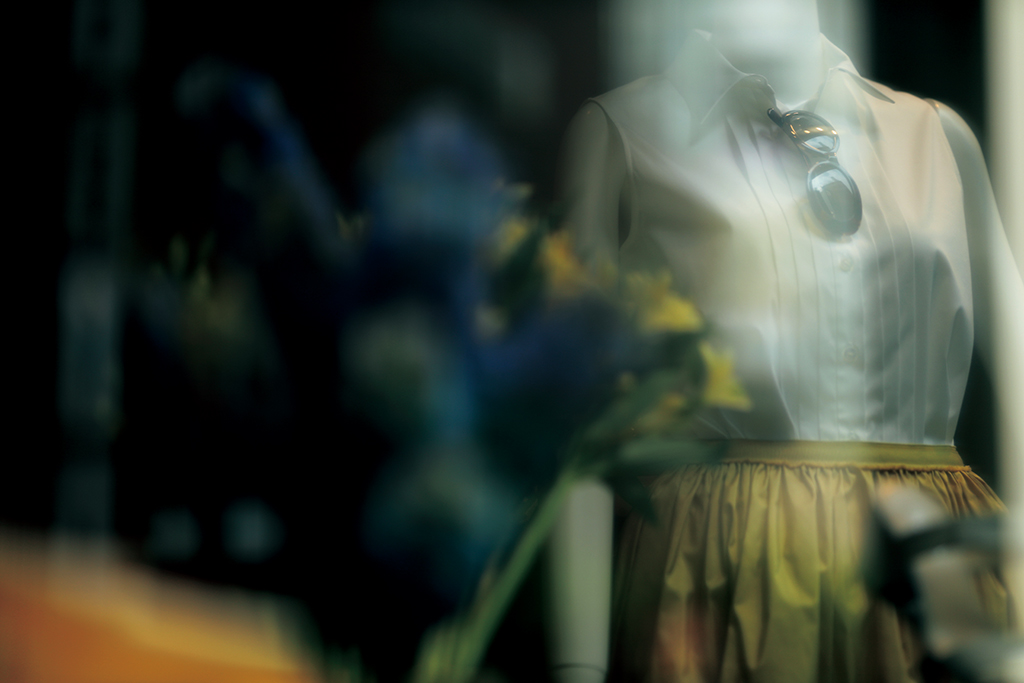 Mannequin in white blouse shot through window