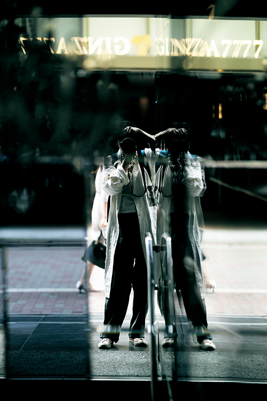 Photographer shooting her own reflection in glass panels
