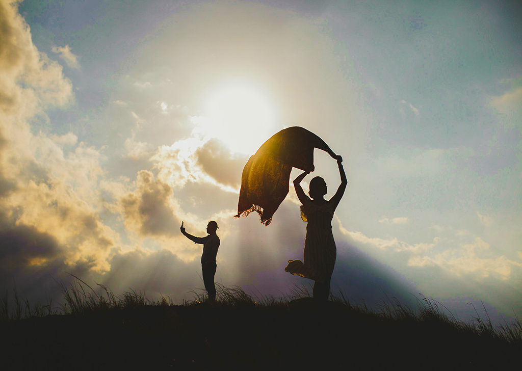 pre-wedding shoot couple on a hill against back light