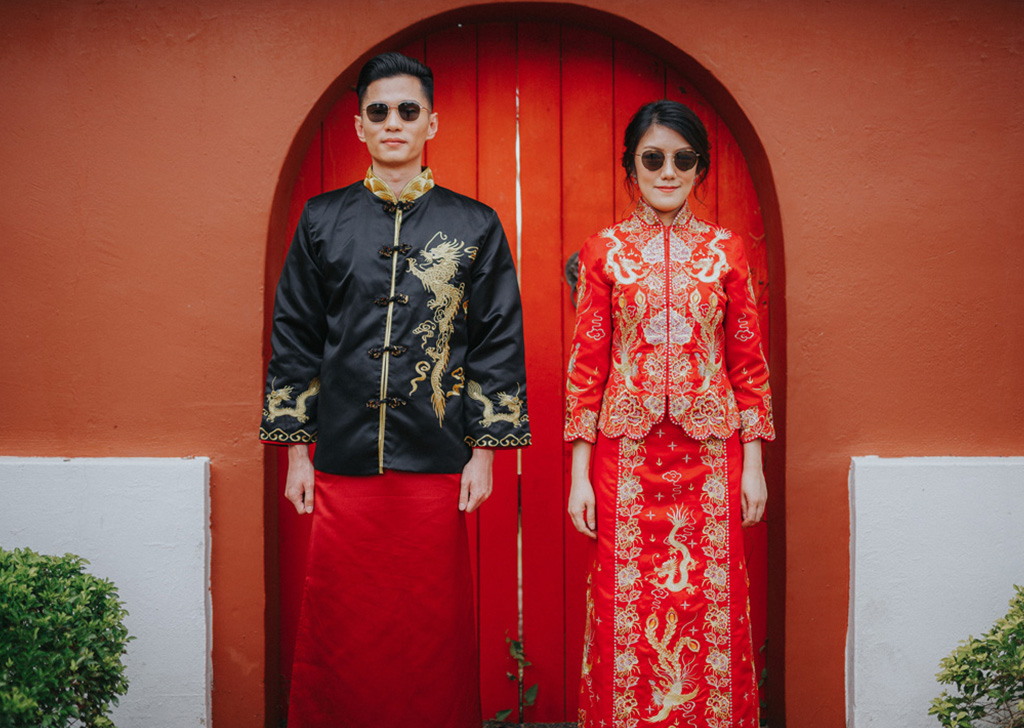 Bride & groom in traditional Chinese wedding costume in a fun pose