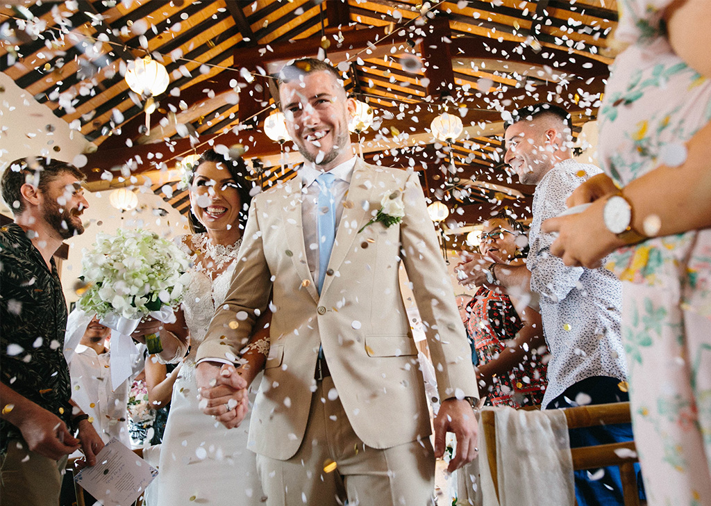 Wedding couple walking into room with confetti
