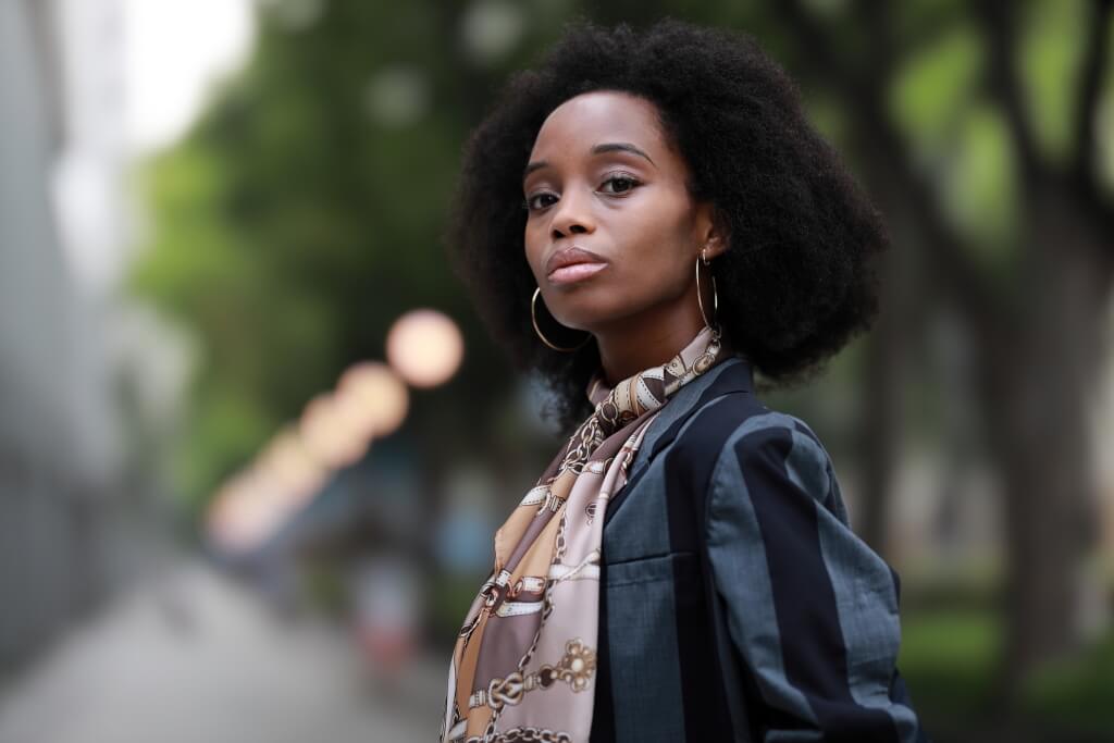 Portrait photo of lady with streetlights in background