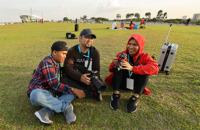 3 photographers chatting on the grass