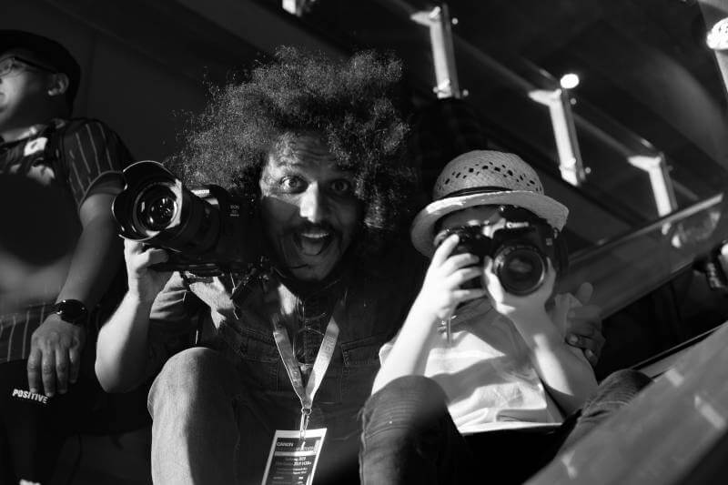 Young photographer with EOS 40D posing with man