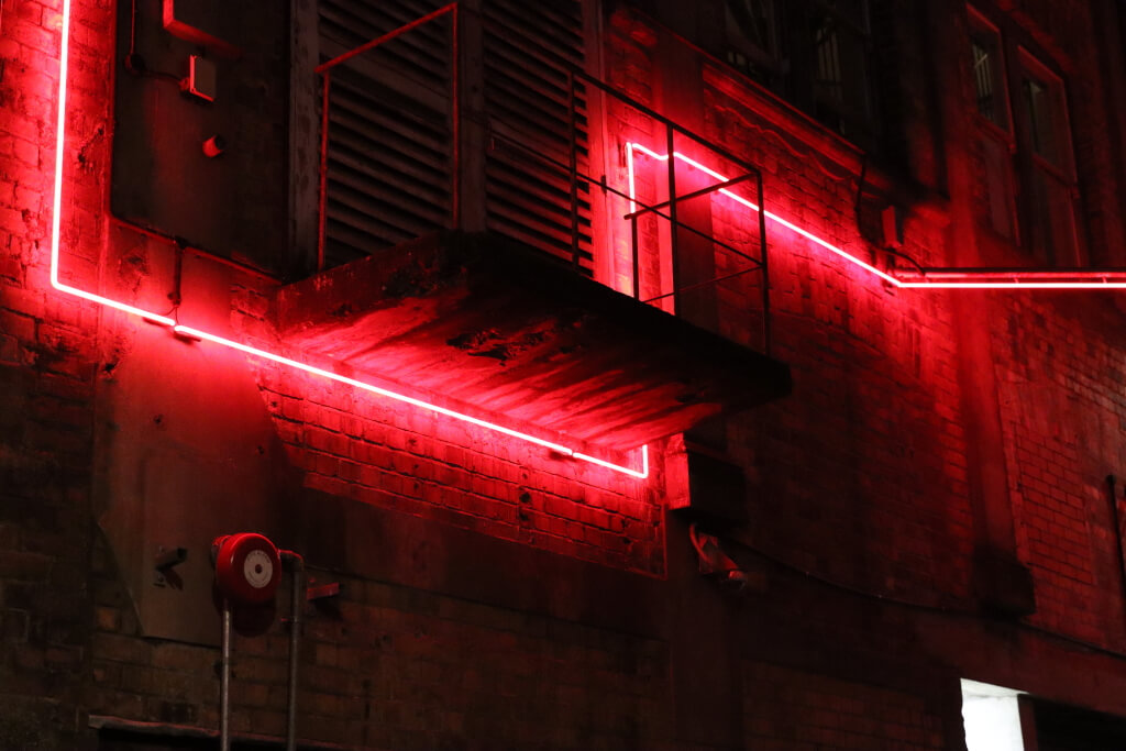 Red neon lights on wall at night