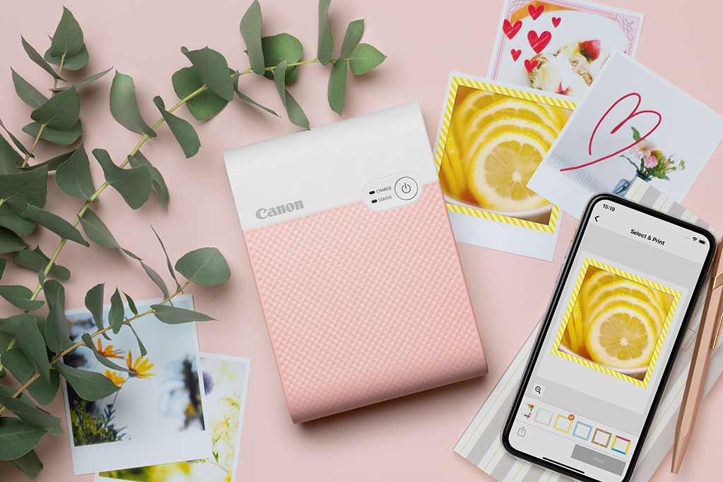 Pink photo printer with smartphone and photo prints