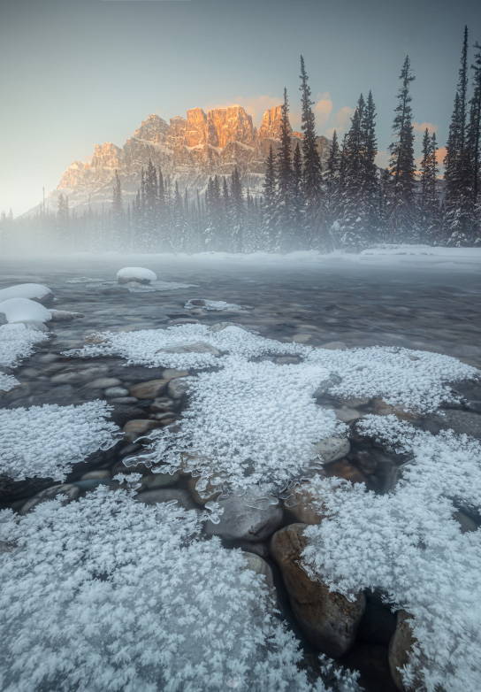 Vertical shot of frosty lake in front of mountain
