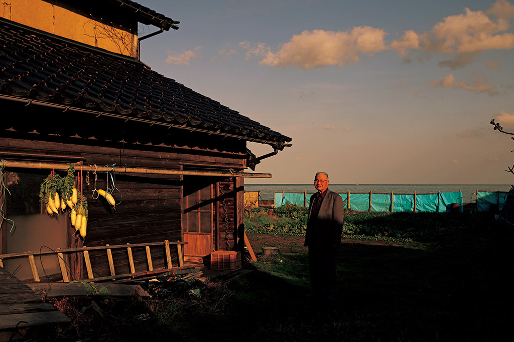 Man standing next to wooden hut