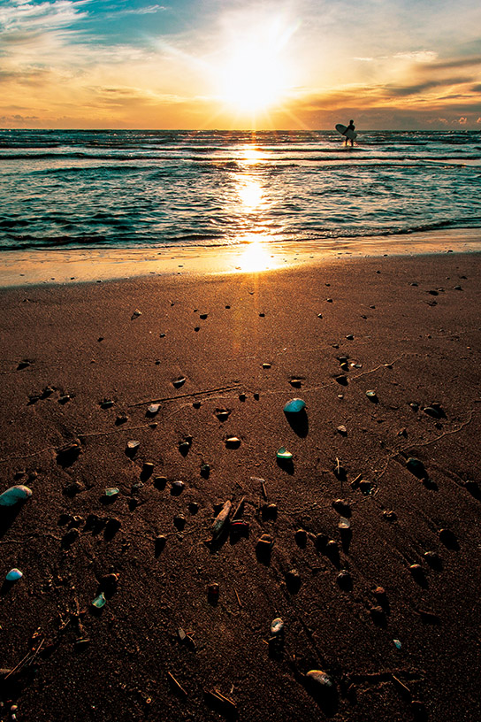 Pebbles on beach at sunset in backlight