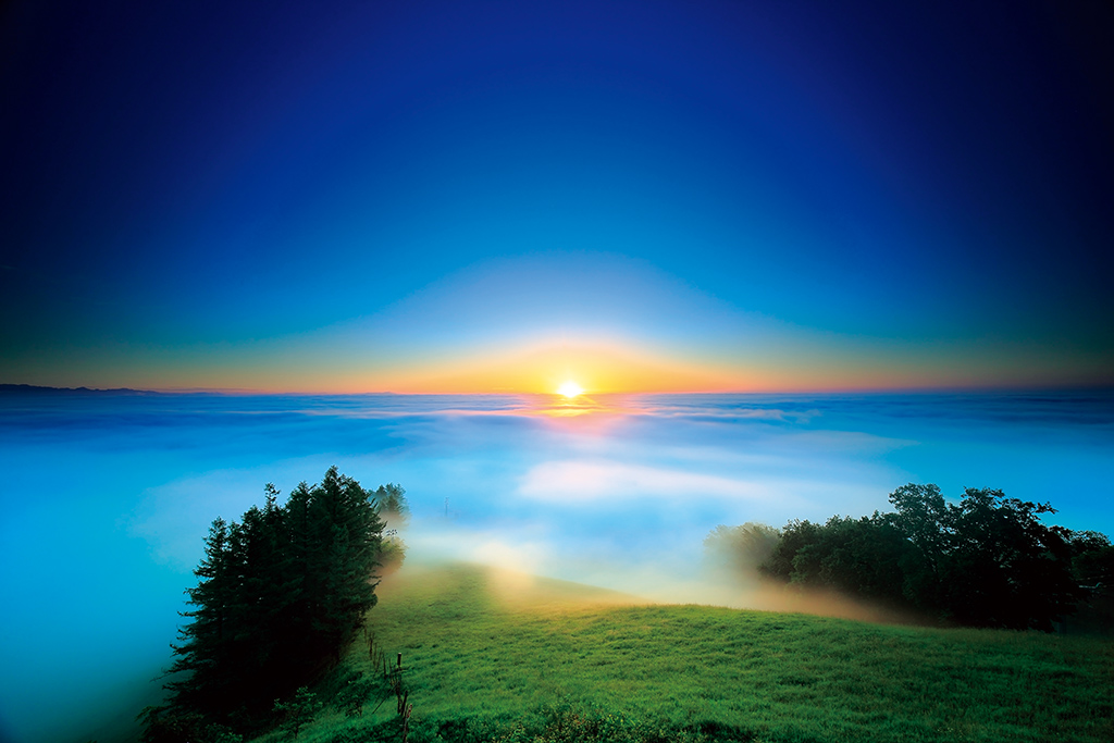 Blue sunrise in sea of clouds