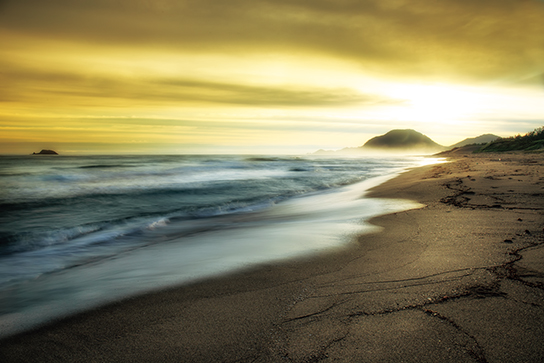 Sepia-toned flowing clouds over seashore